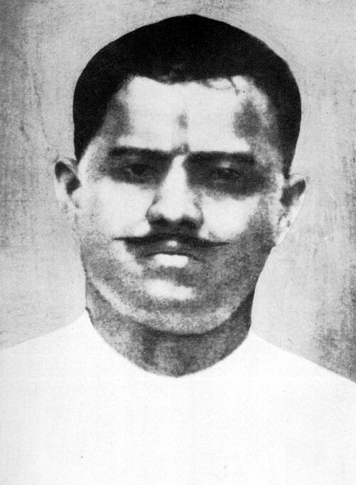 Black-and-white photographic portrait of Ram Prasad Bismil as a young man in a white collarless kurta, with a tilak mark on his forehead and a moustache.
